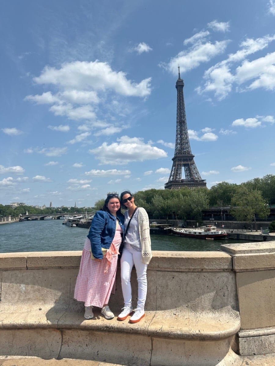 Happy clients smiling in front of the Eiffel Tower in Paris