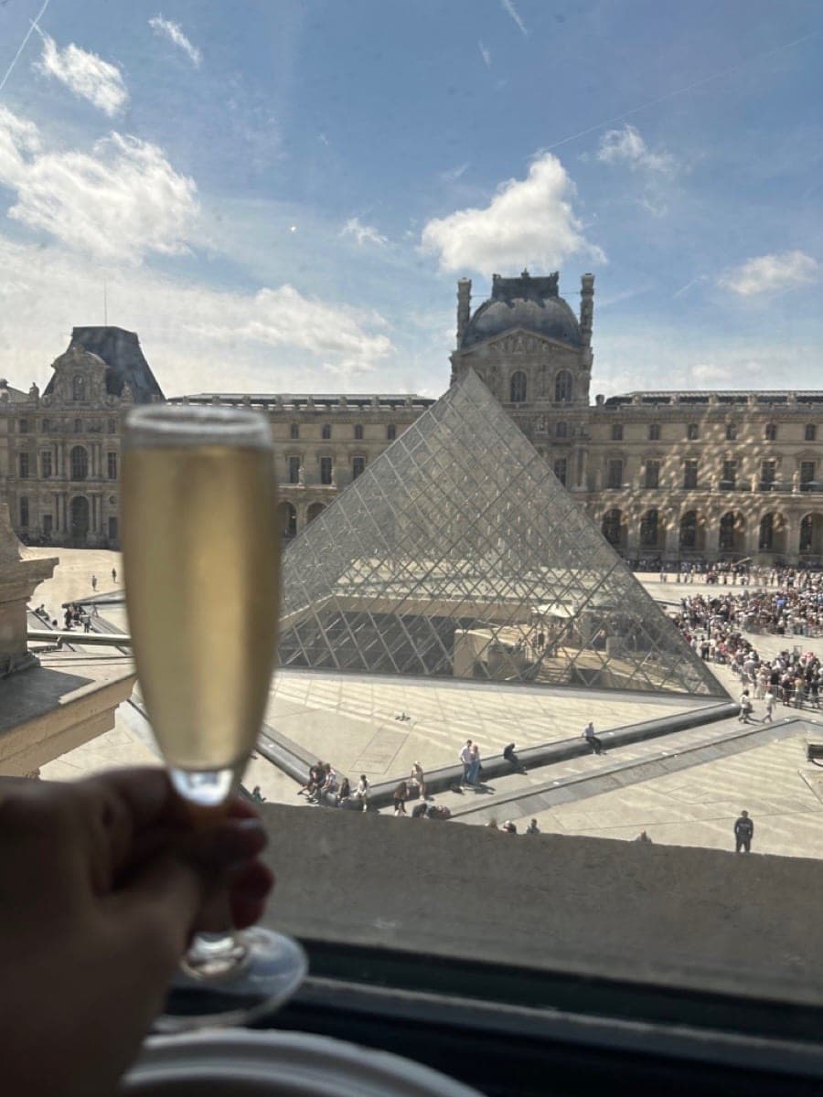 Champagne toast overlooking the Louvre Pyramid in Paris